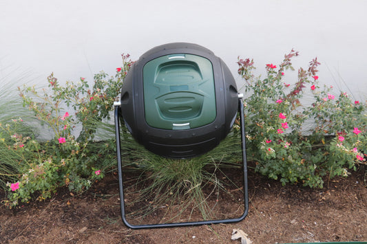 Black and green compost bin in a garden setting
