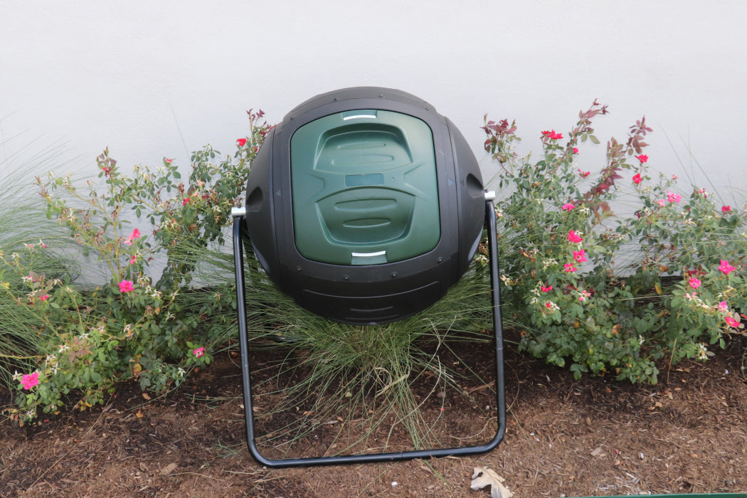 Black and green compost bin in a garden setting
